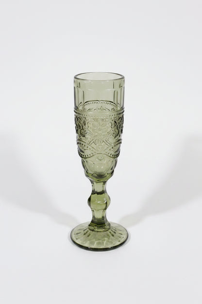 Green glass goblet with intricate design on a white background