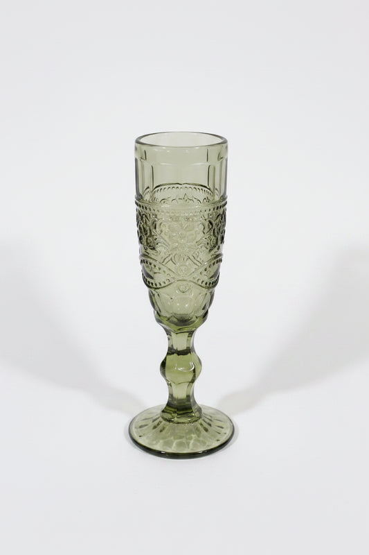 Green glass goblet with intricate design on a white background