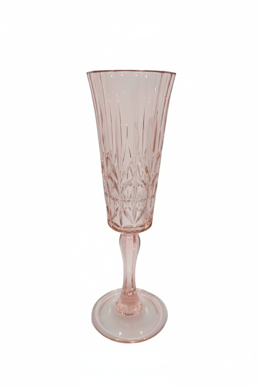 Pink glass flute with intricate design on a white surface