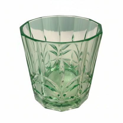 Green glass vase with intricate patterns on a white surface